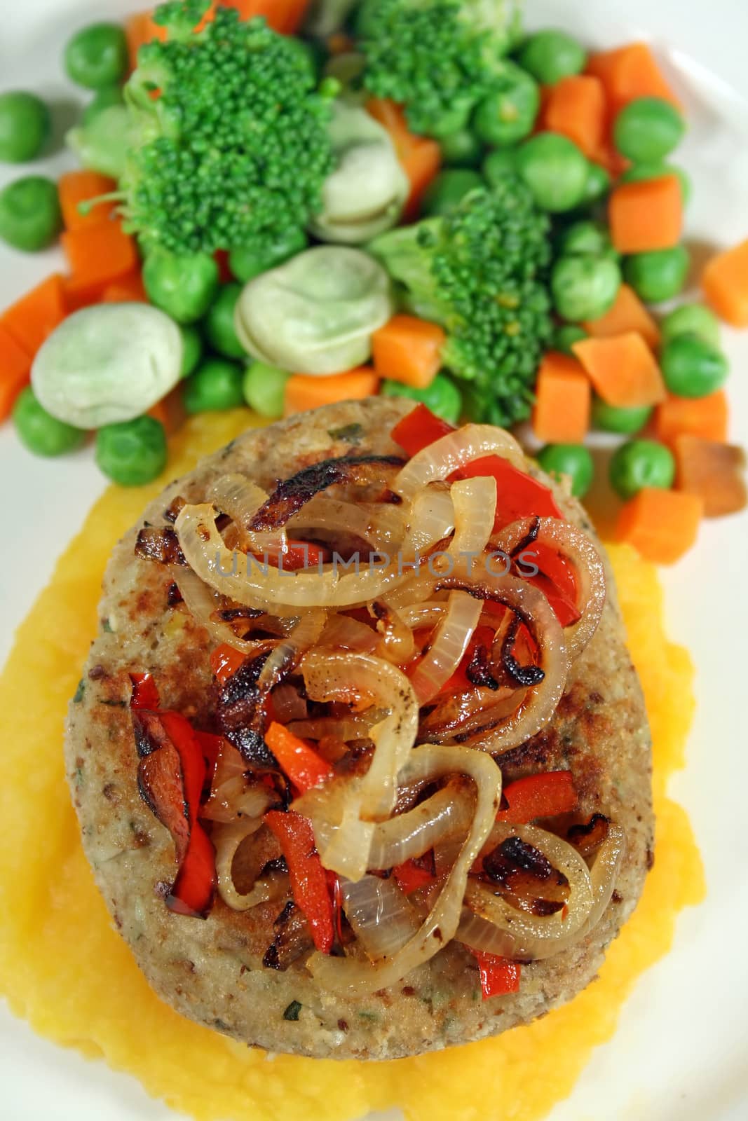 Chicken patty on a bed of pumpkin with fresh steamed vegetables.