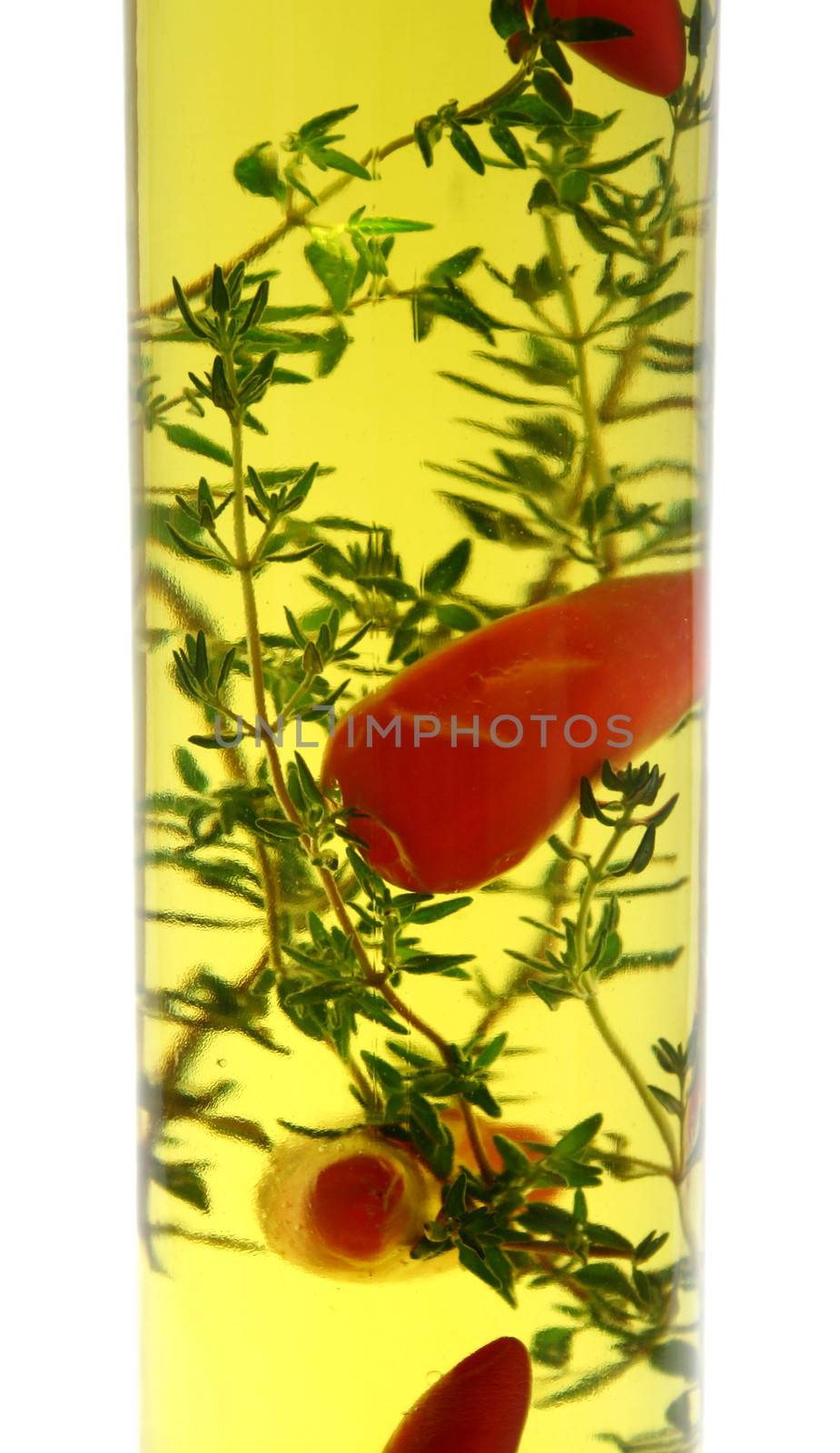 Red chillies and thyme preserved in a bottle of olive oil.