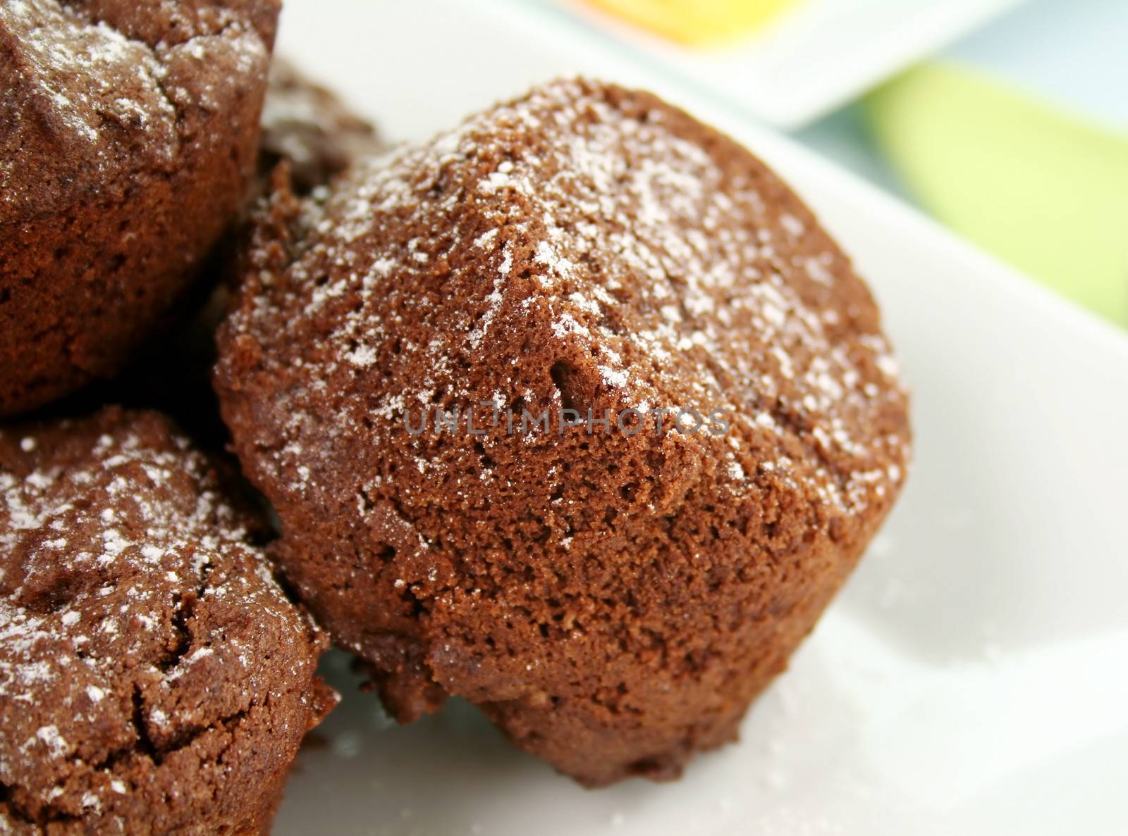 Chocolate brownies stacked up sprinkled with icing sugar.