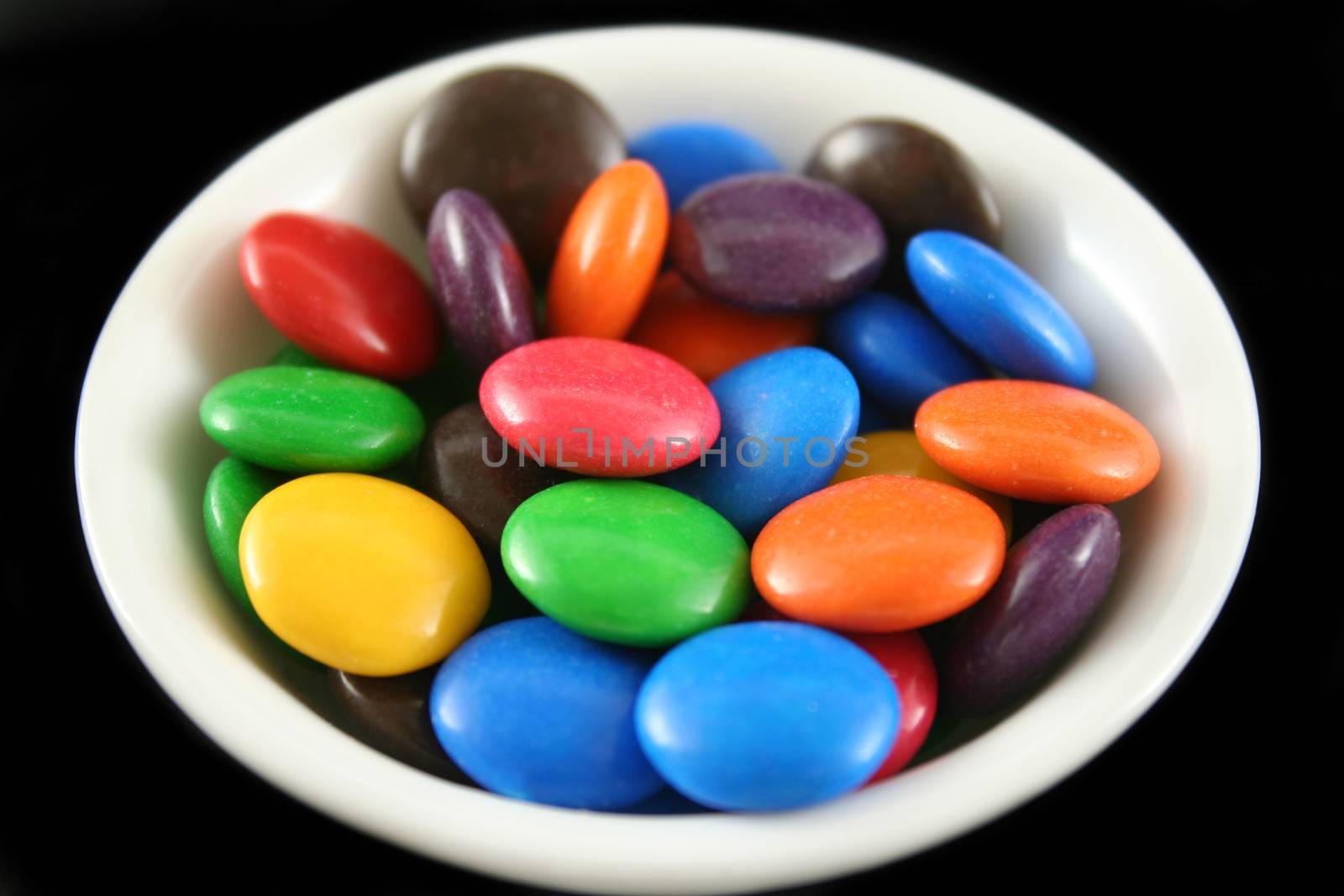 Assorted crunchy and colorful chocolate buttons.