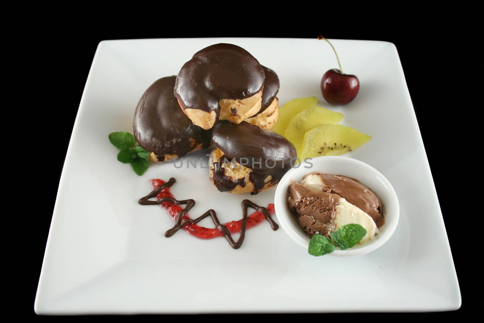 Chocolate profiteroles with kiwi fruit and ice cream.