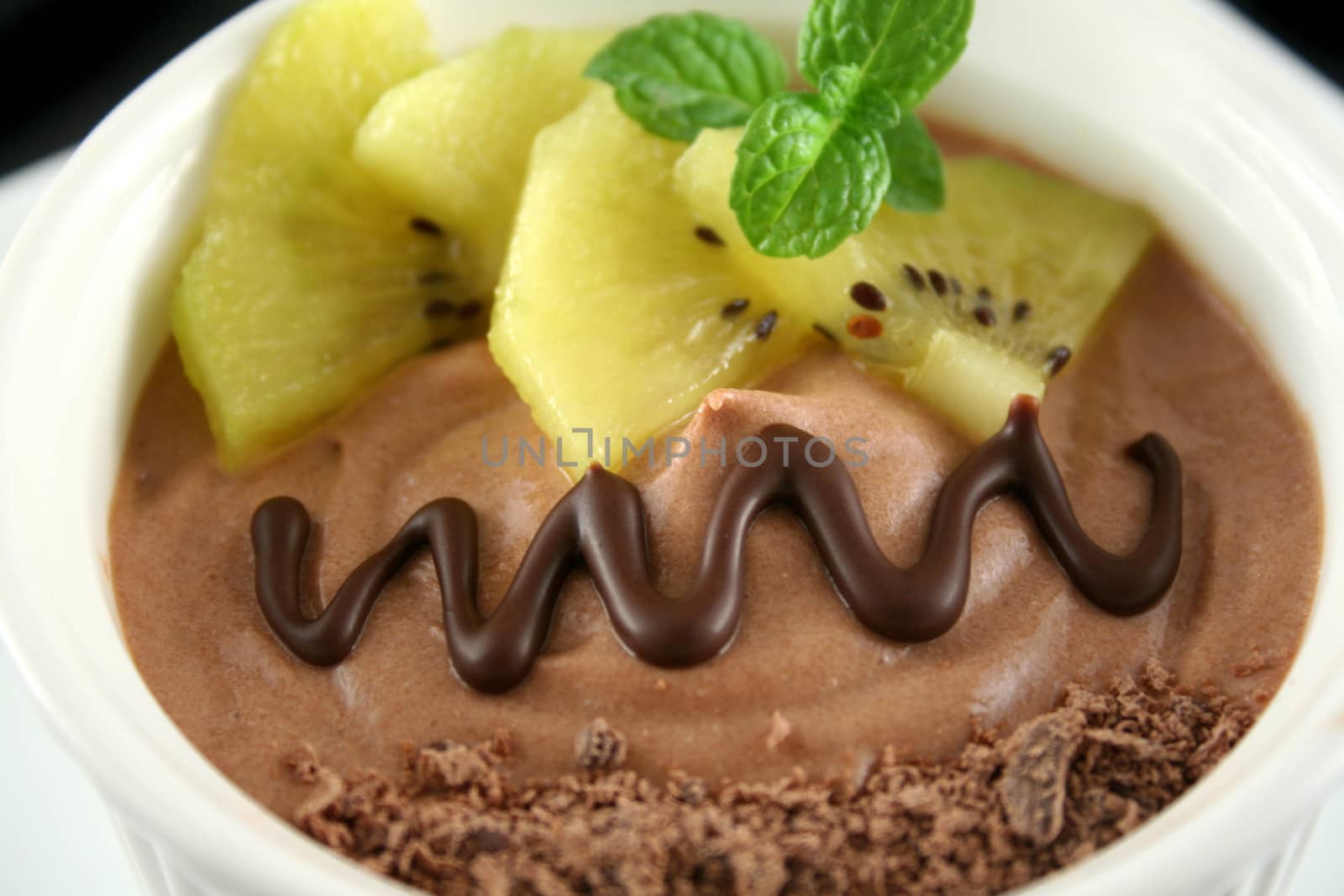 Chocolate mousse with yellow kiwi fruit and mint.