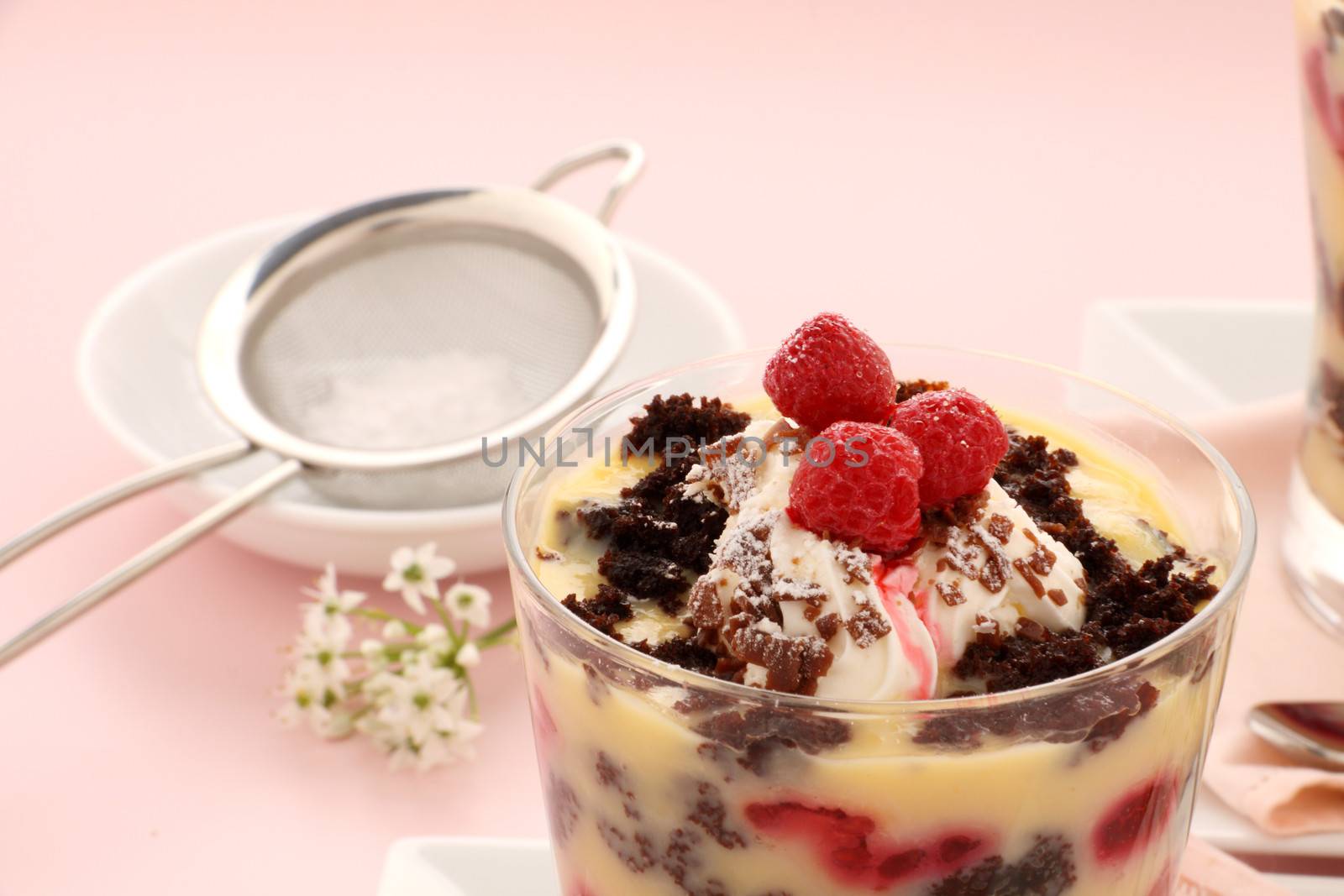 Delicious chocolate trifle dessert served in a glass topped with raspberries.