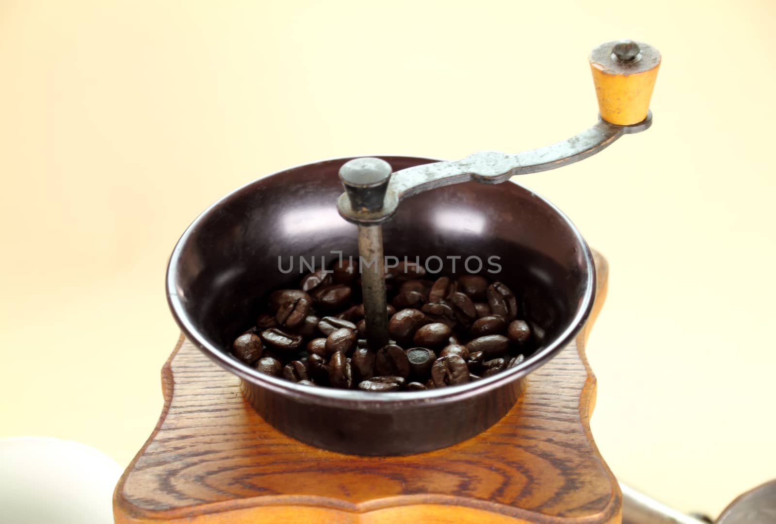 Old fashioned coffee grinder with coffee beans.