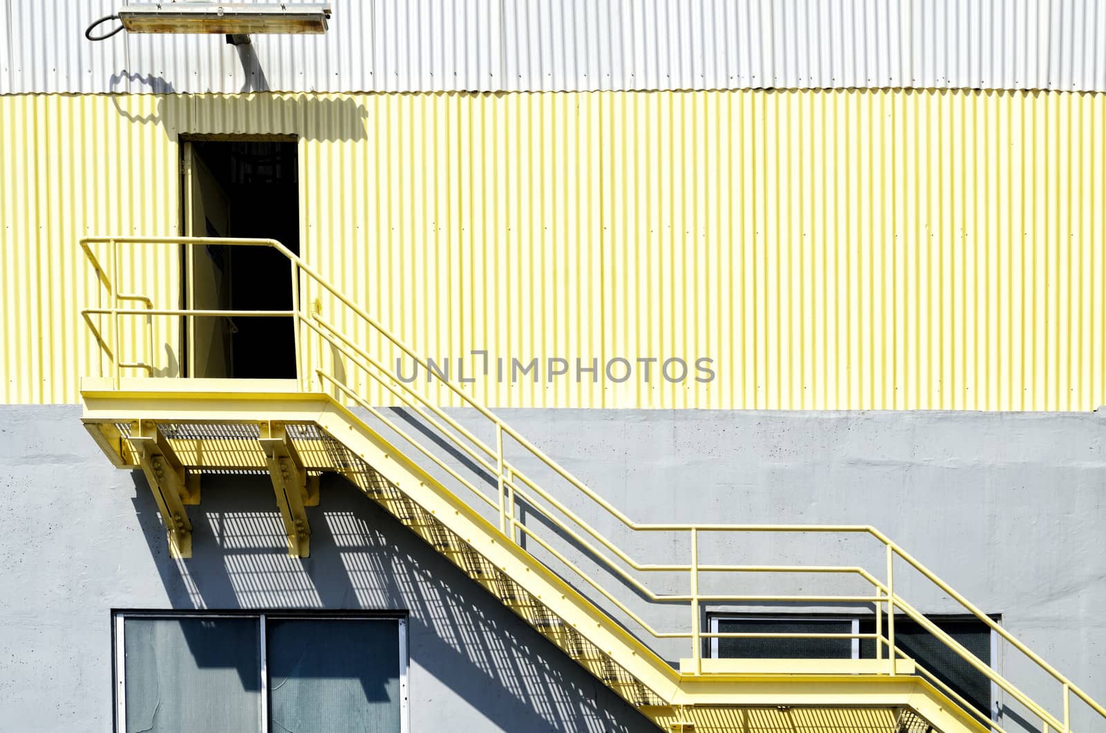 Yellow industrial stairs and galvanized iron wall