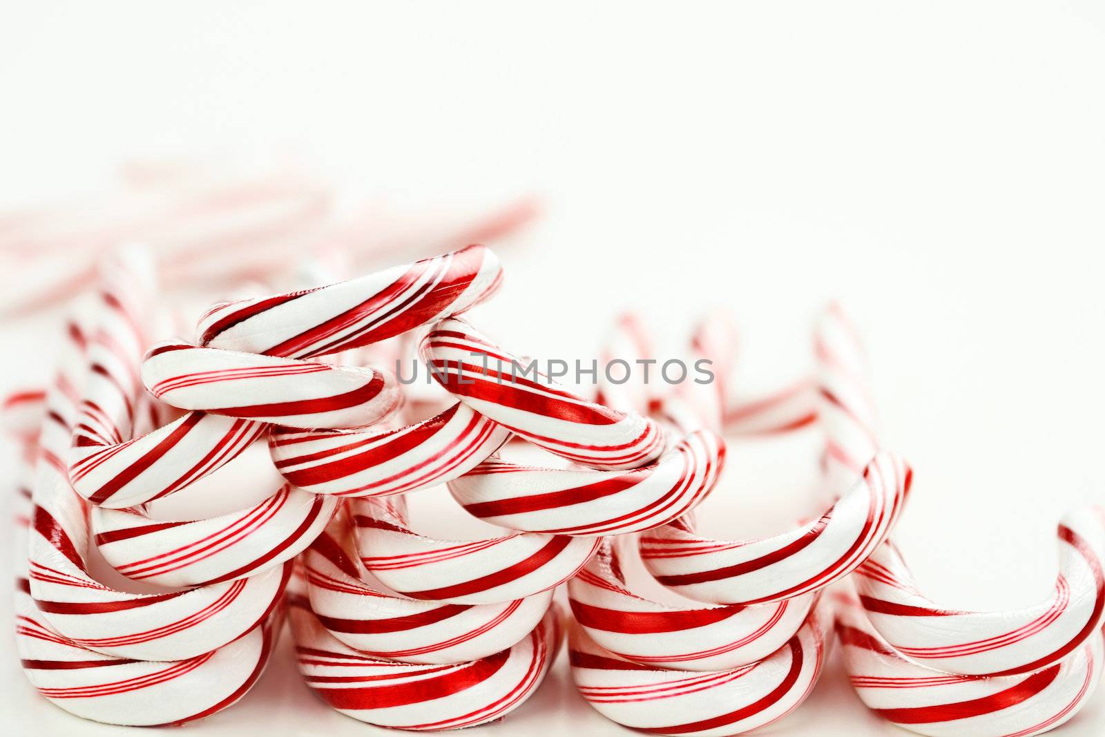 Row of candy canes on a white background with copy space.