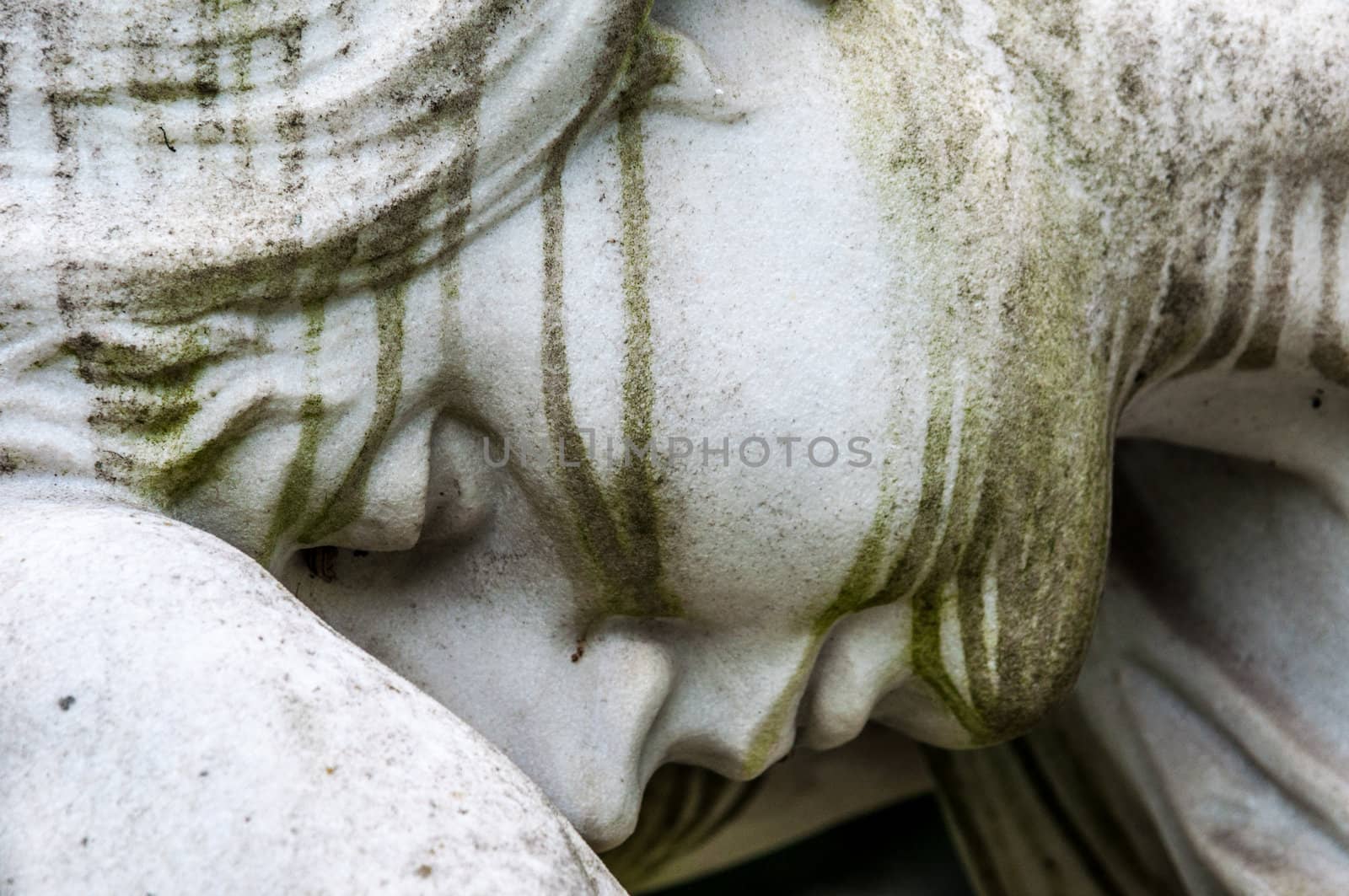 detail of a mourning sculpture on a cemetery