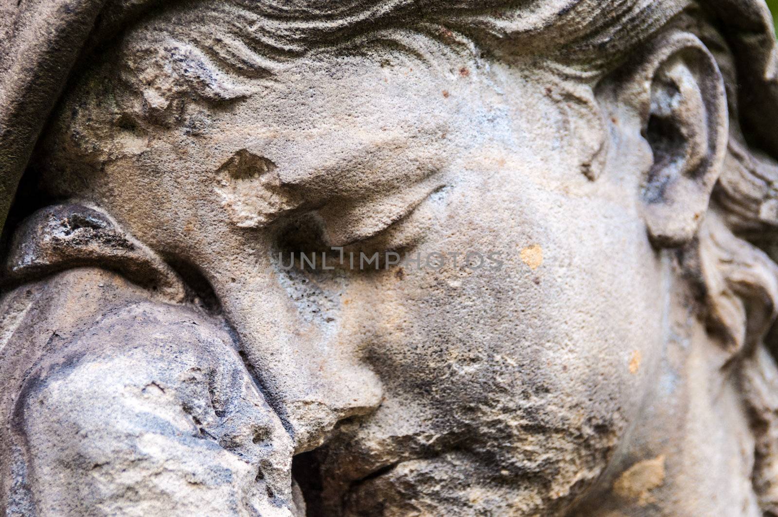 detail of a mourning sculpture on a cemetery