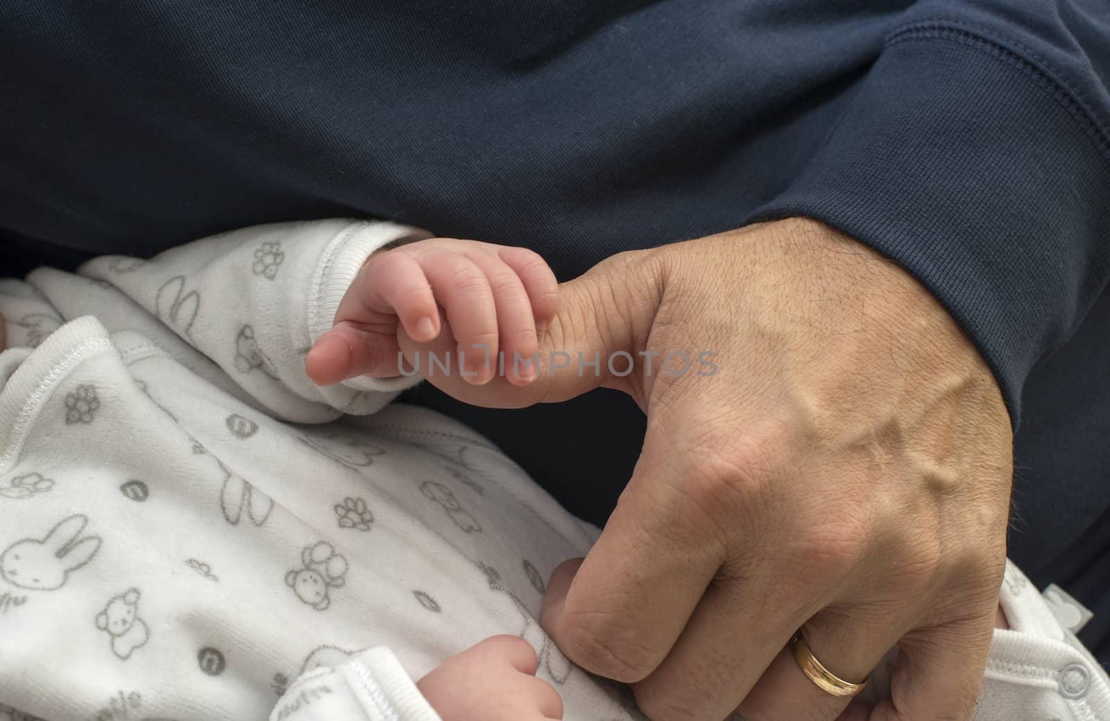 hand of adult man and the young baby