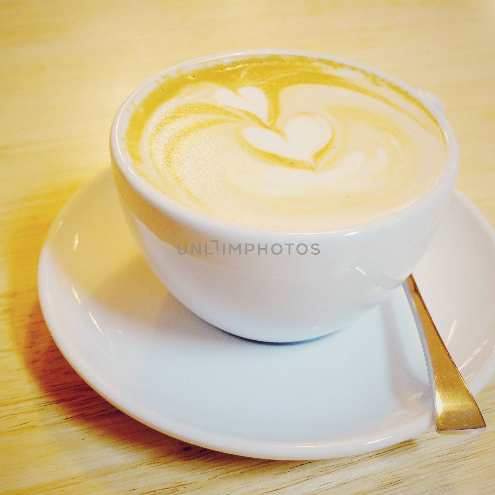 Cappuccino or latte coffee on table with retro filter effect