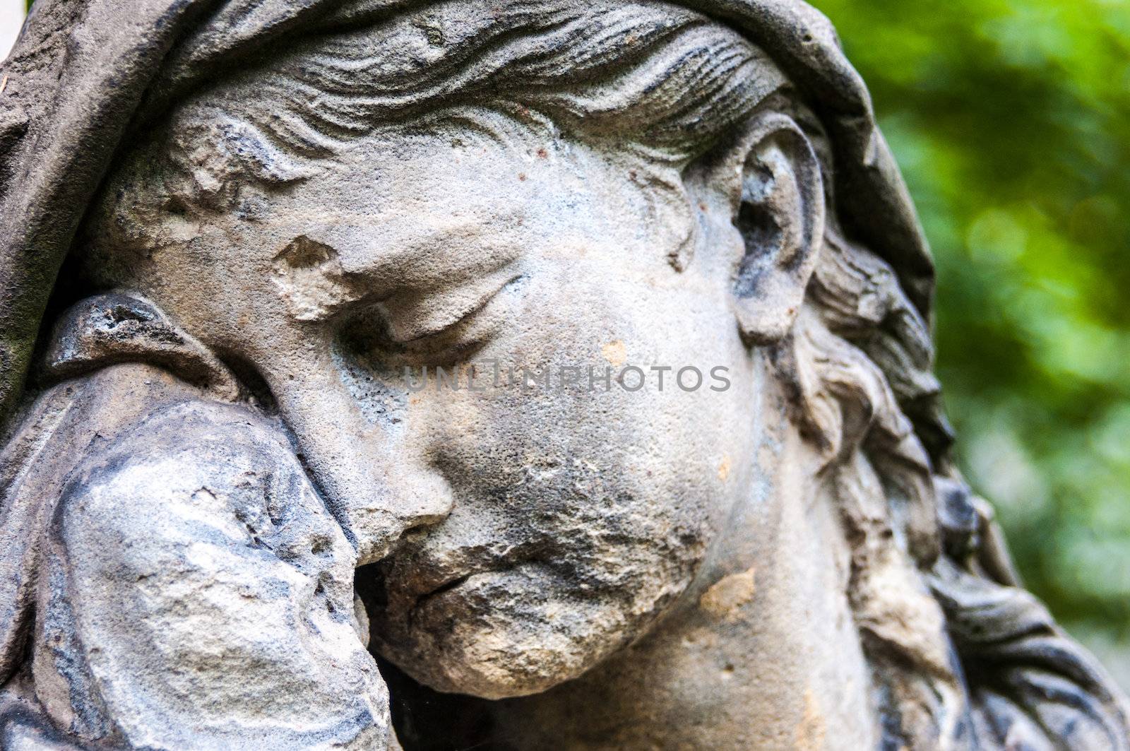 detail of a mourning sculpture on a cemetery