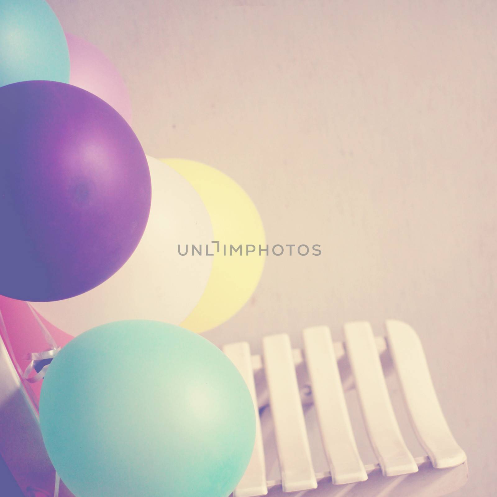 Colorful balloons on chair with retro filter effect by nuchylee
