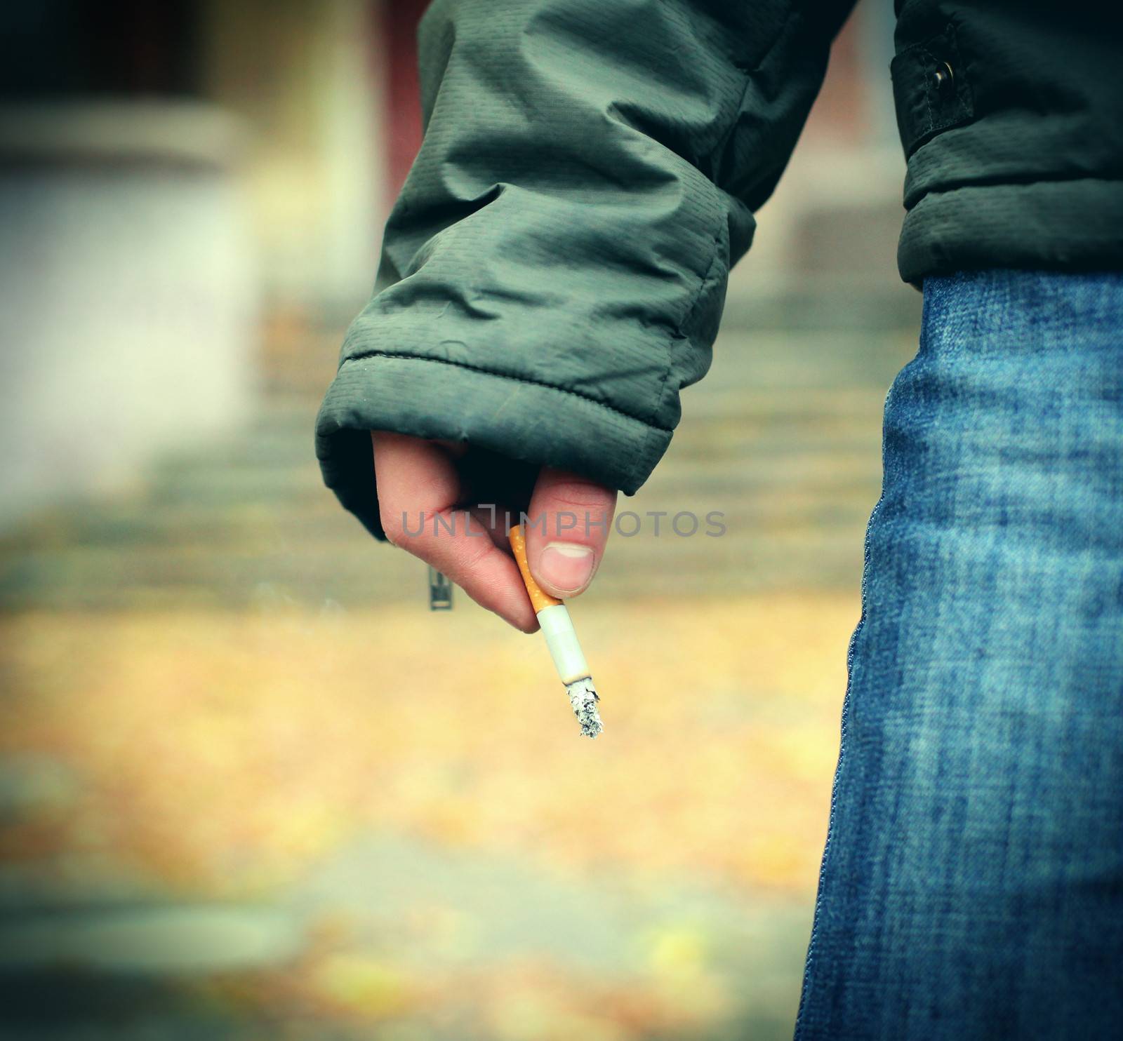Toned photo of Cigarette in the hand closeup outdoor