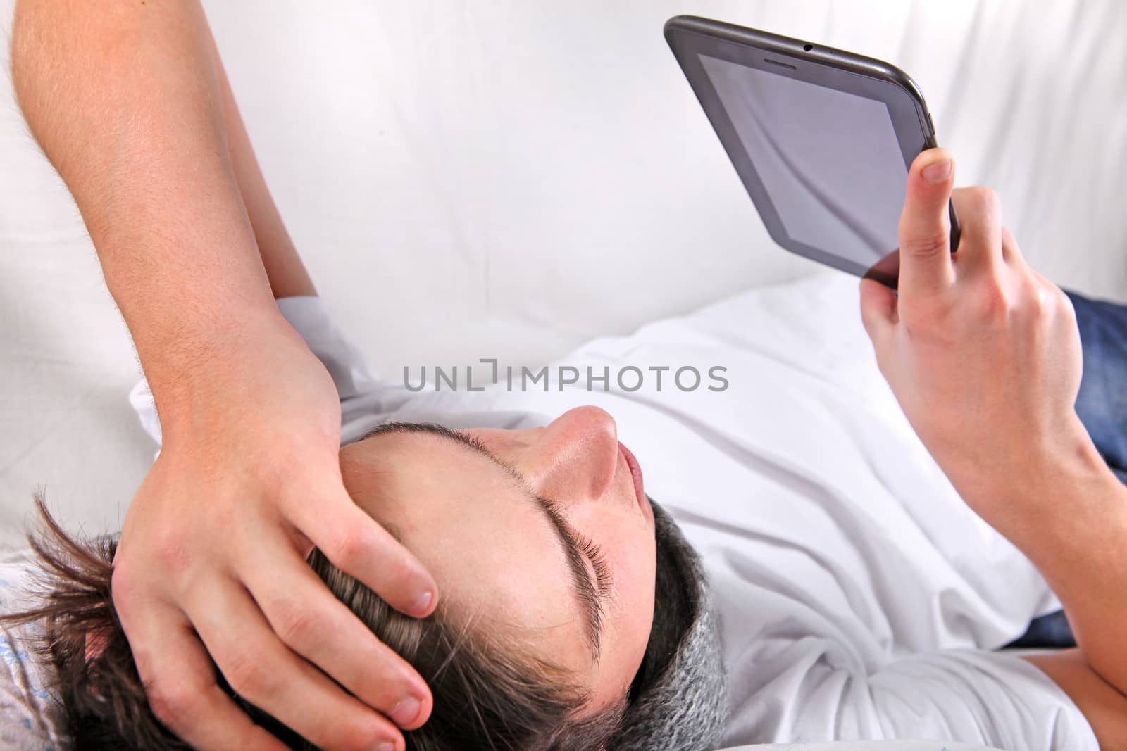 Young Man with Tablet Computer on the bed