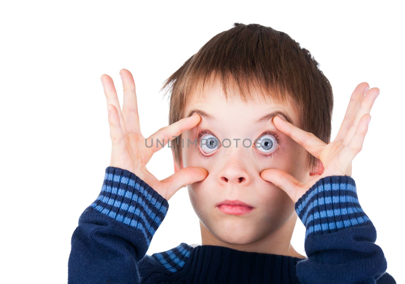 Child wearing blue sweater making funny face holding his eyes wide open on white background