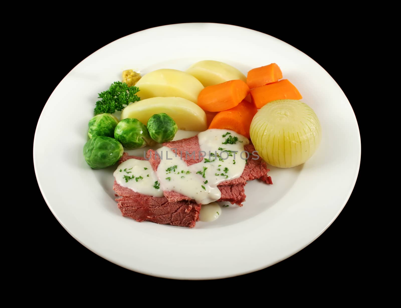 Delicious sliced corn beef with white sauce and vegetables.