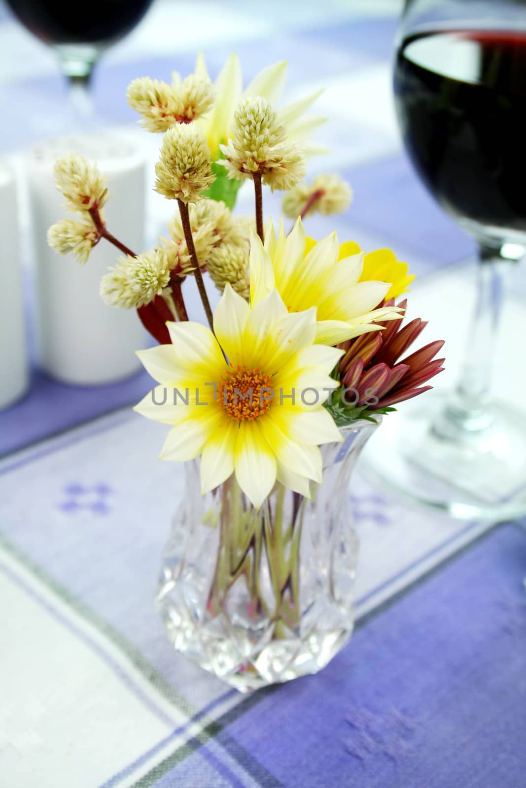 An arrangement of daisies in a vase on the dinner table.