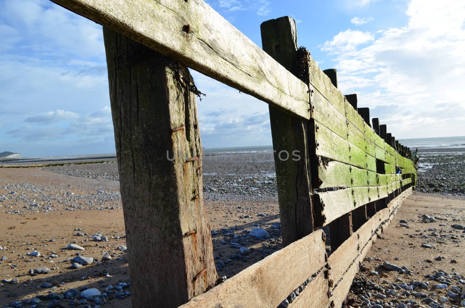 Wooden coastal sea defence breakwater along a stretch of beach in Sussex,England.