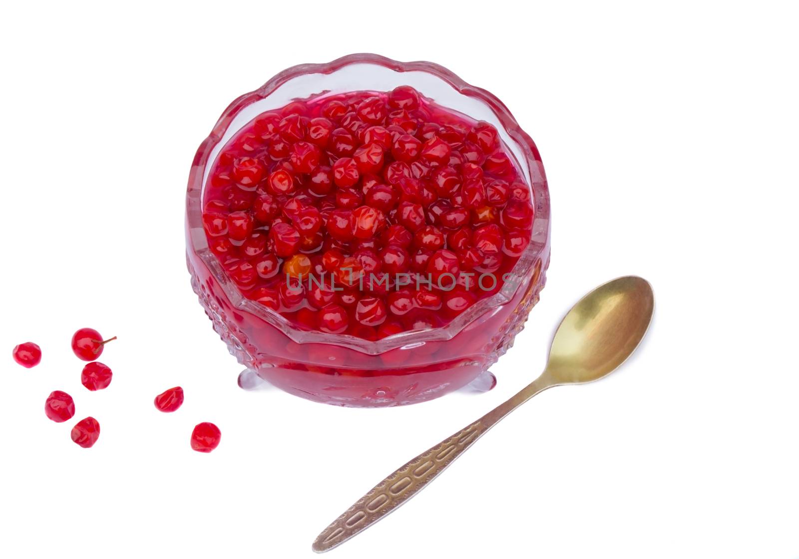 Bright red berries in a crystal vase filled with sugar syrup. Presented on a white background.