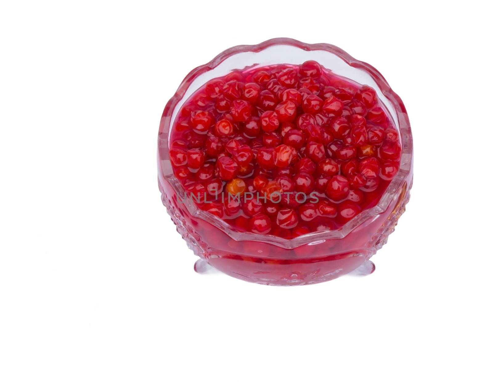 Bright red berries in a crystal vase filled with sugar syrup. Presented on a white background.