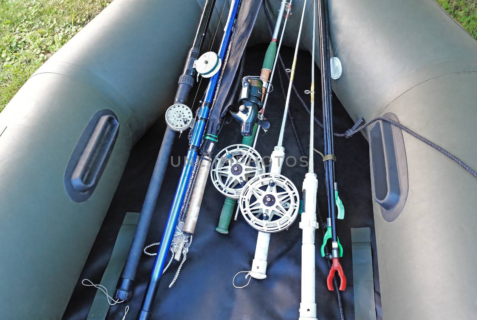 Rods and spinning prepared for fishing, lie in pressurized rubber boat