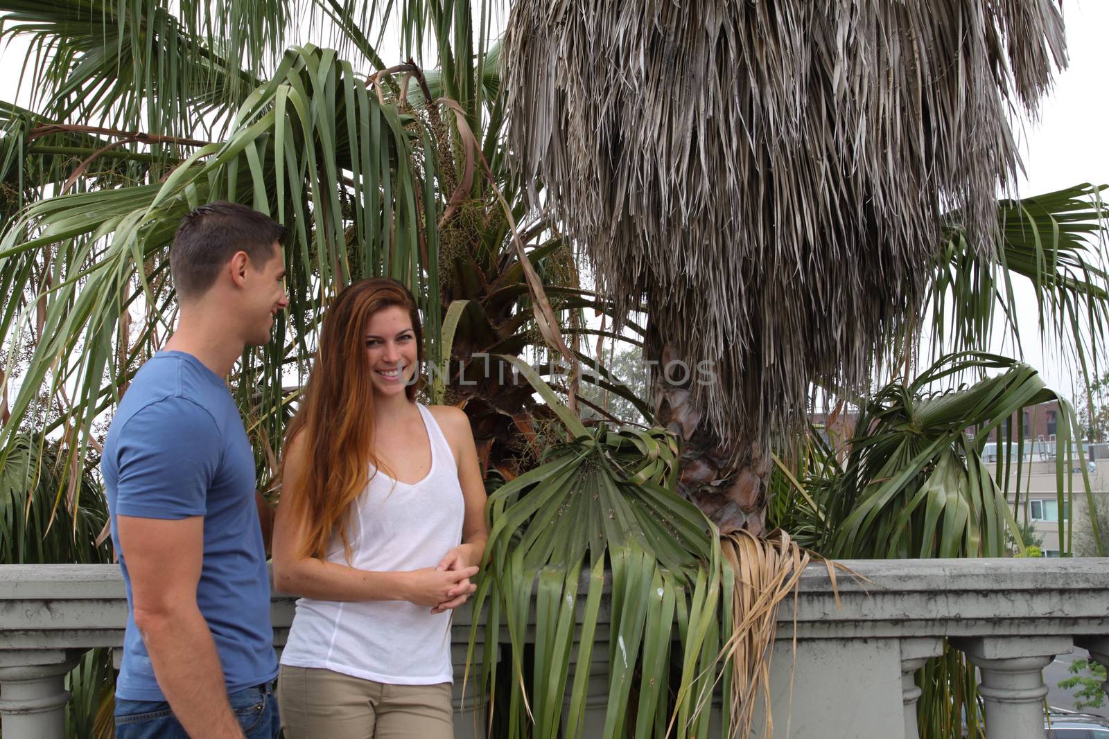 Young couple in front of a palm tree.