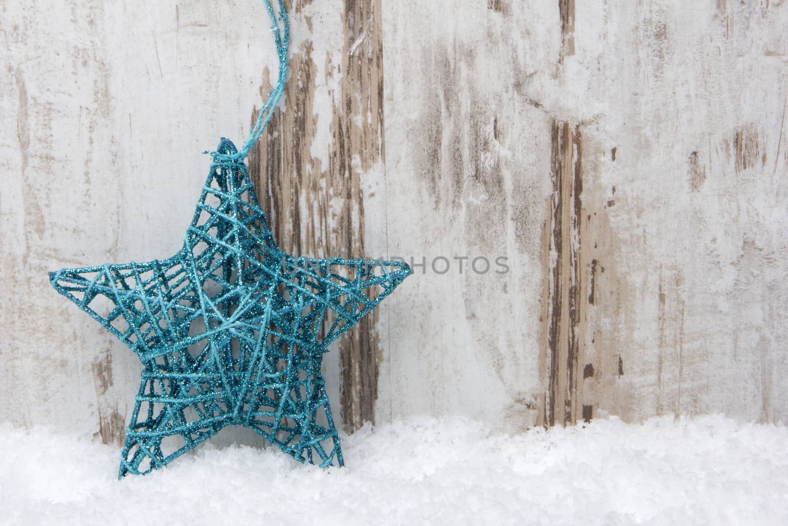 Christmas decoration with wood background, snow and christmas star turquoise