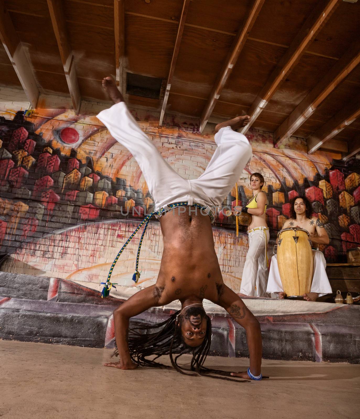 Capoeira performer with dreadlocks in handstand