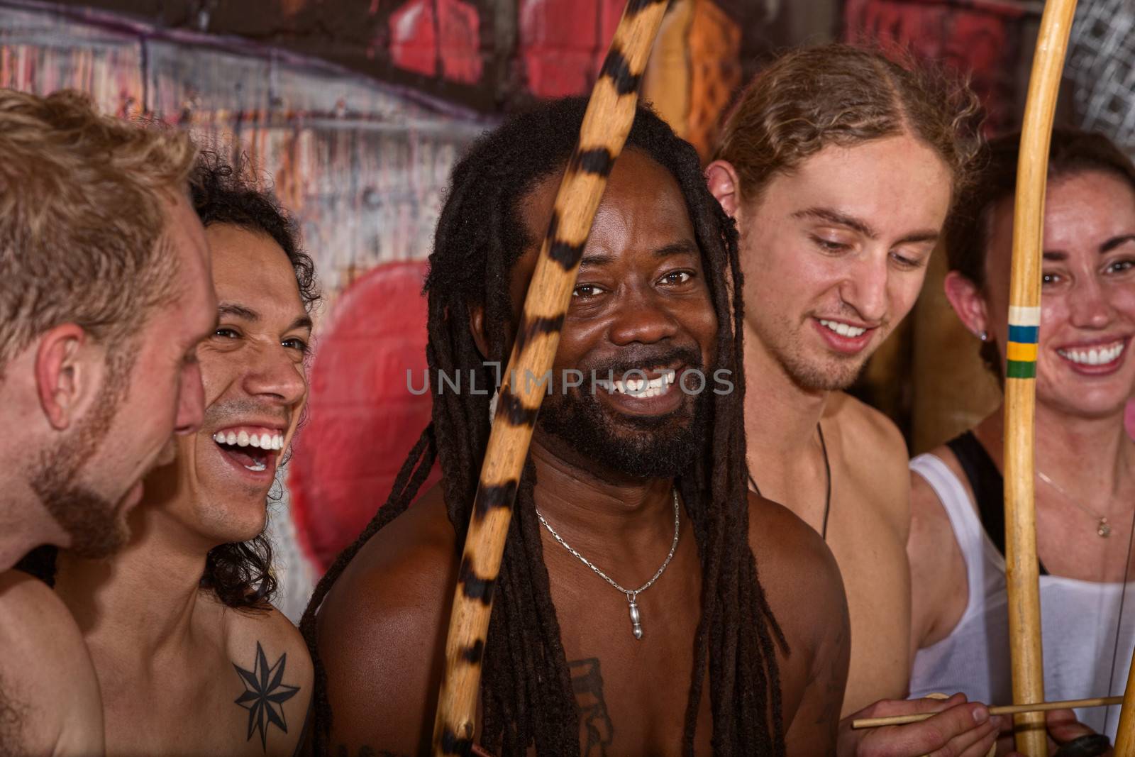 Handsome Brazilian man with group of capoeira performers