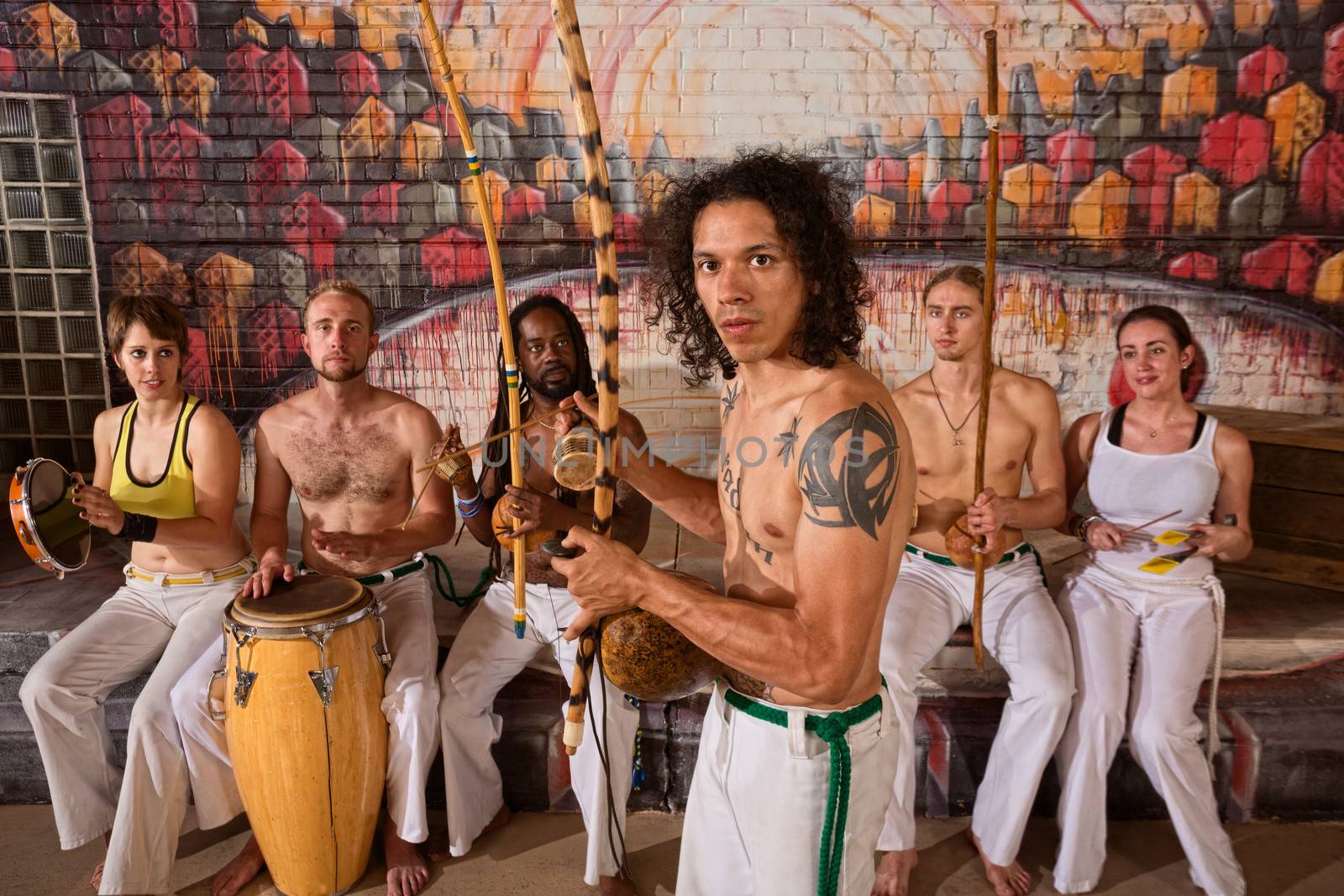 Handsome Latino Capoeira expert with musical instruments