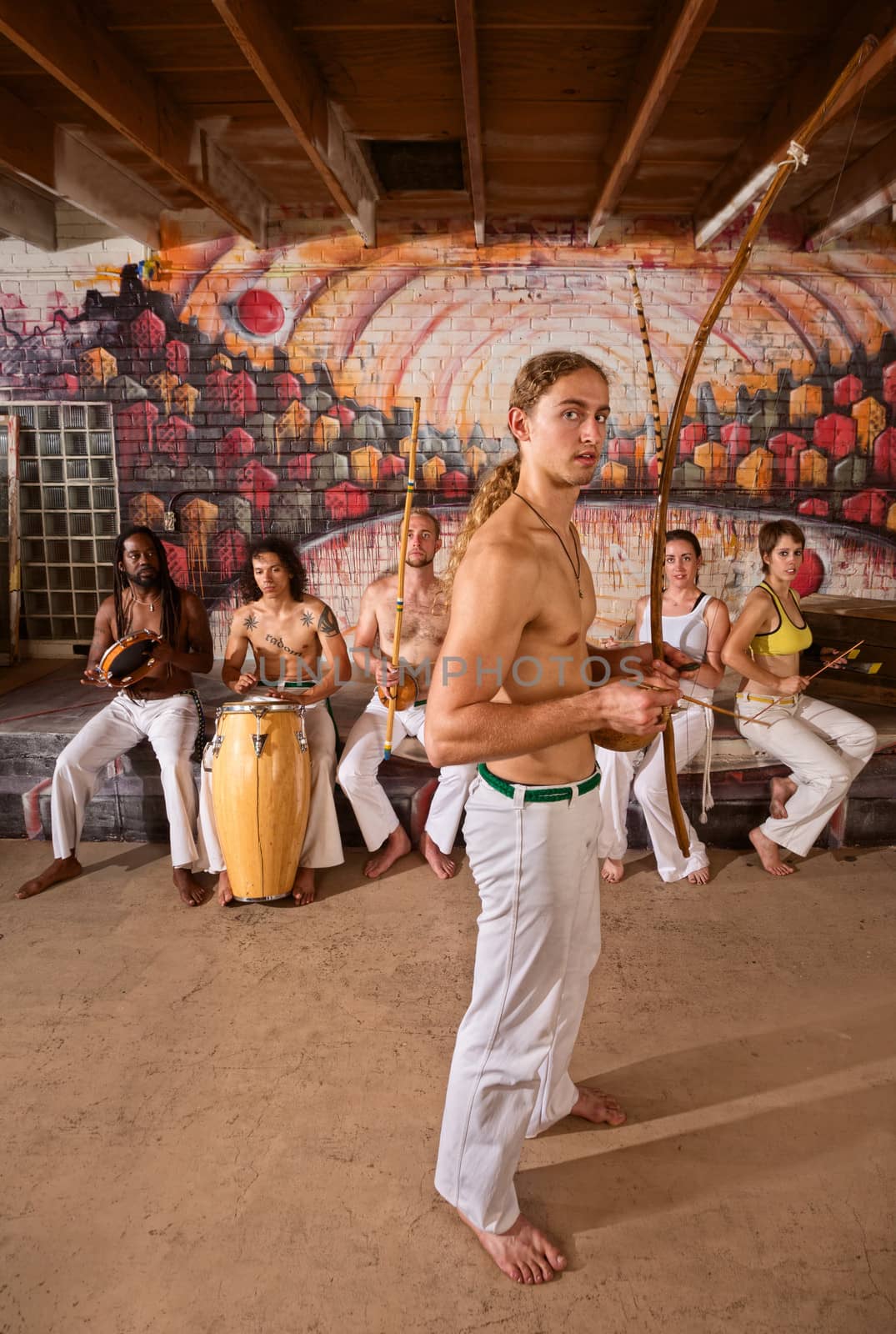 Group of 6 traditional Capoeira performers in urban building