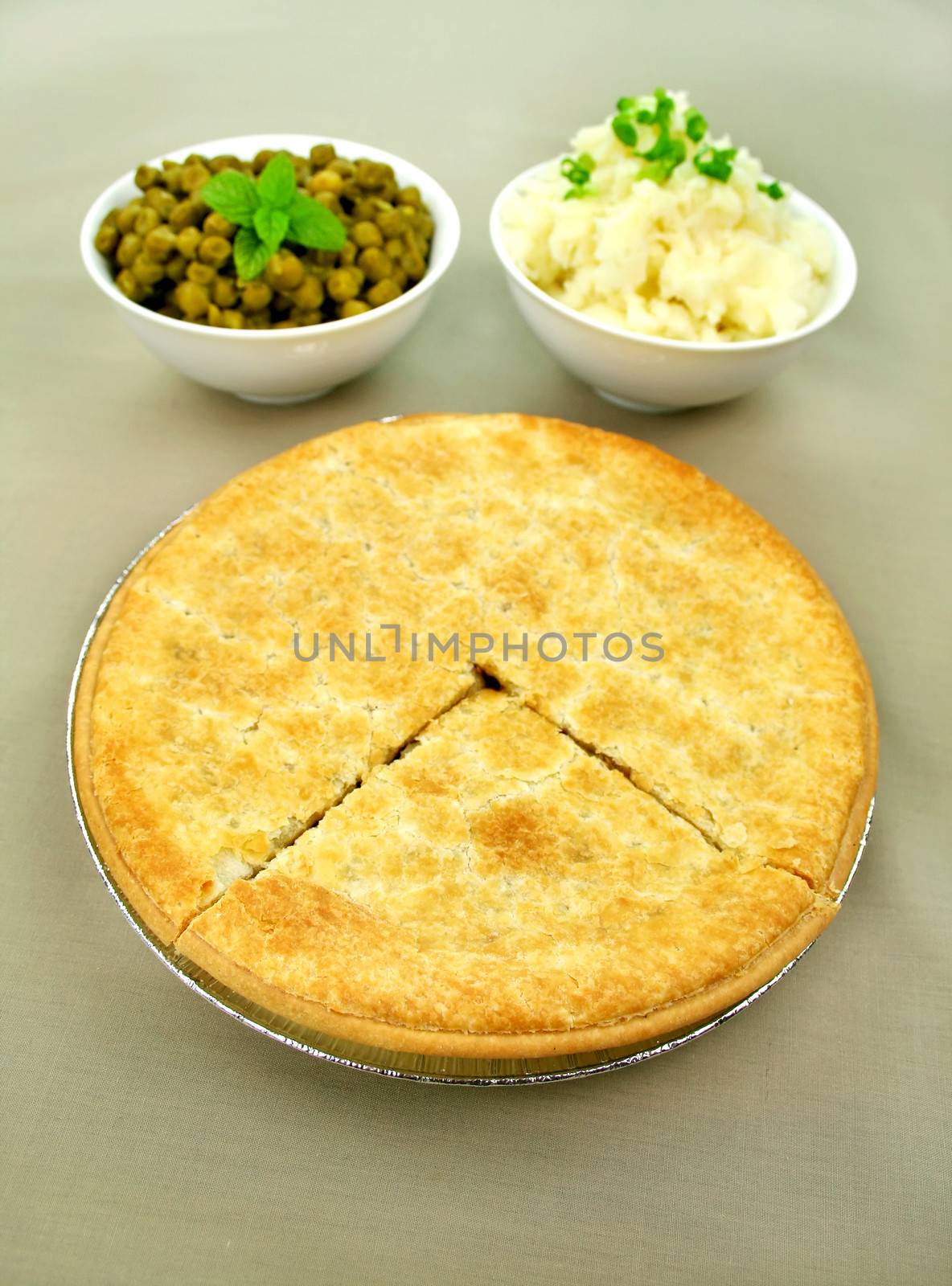 Family beef pie with peas and mashed potato ready to serve.