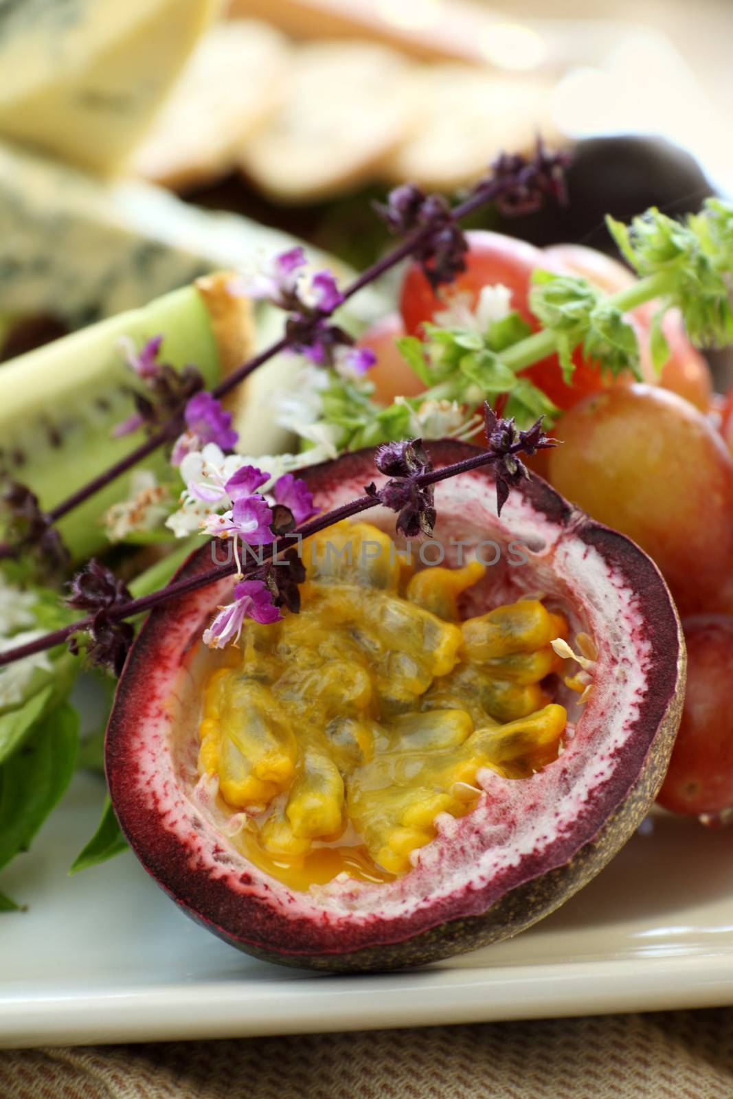 Delicious passionfruit with fresh grapes, basil flowers and a variety of cheeses.