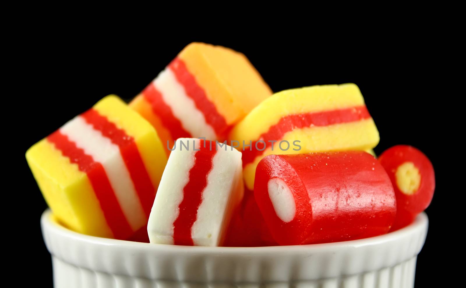 Colorful striped fruit flavored candies in a bowl.