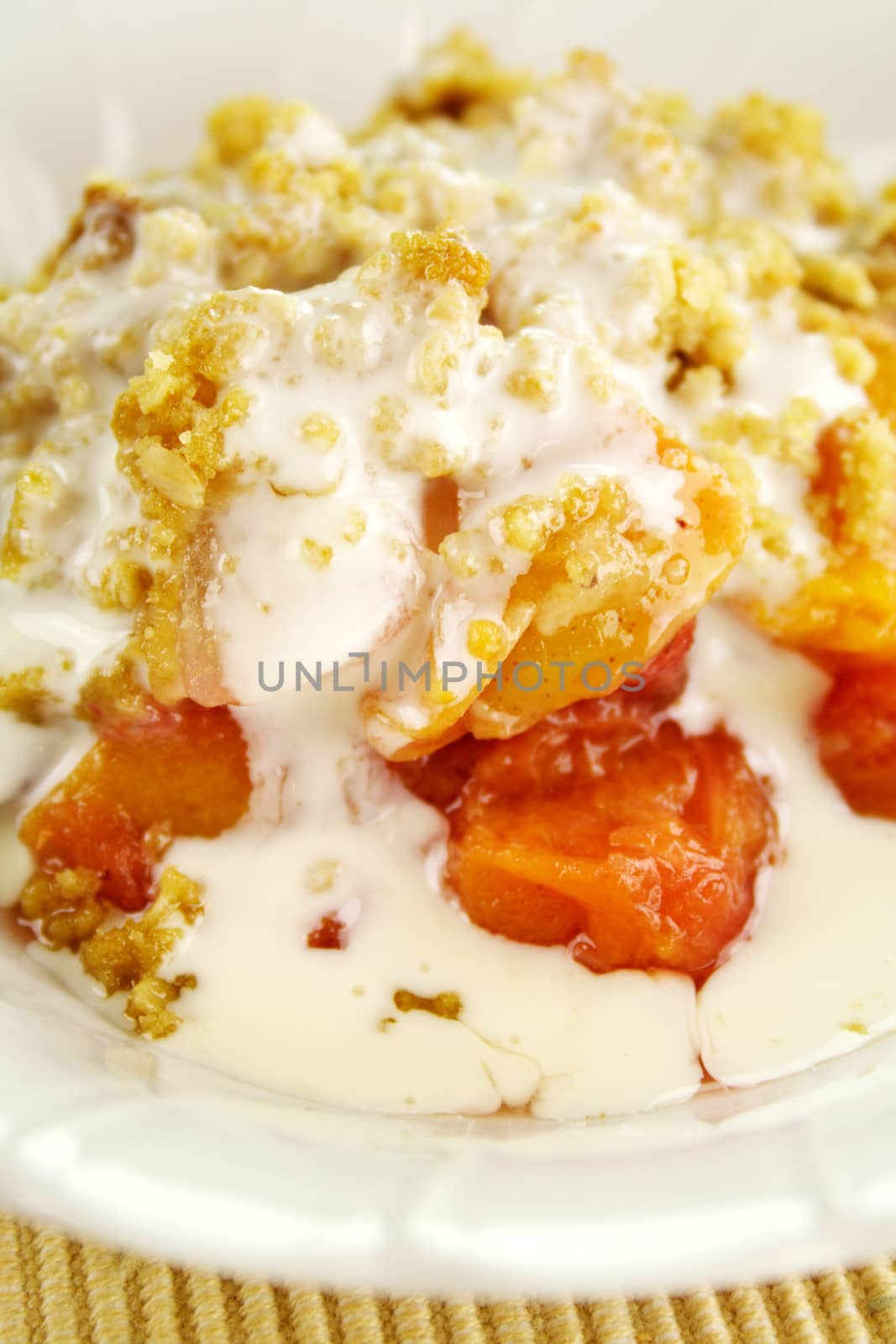 Seasonal fruit crumble dessert with cream ready to serve.