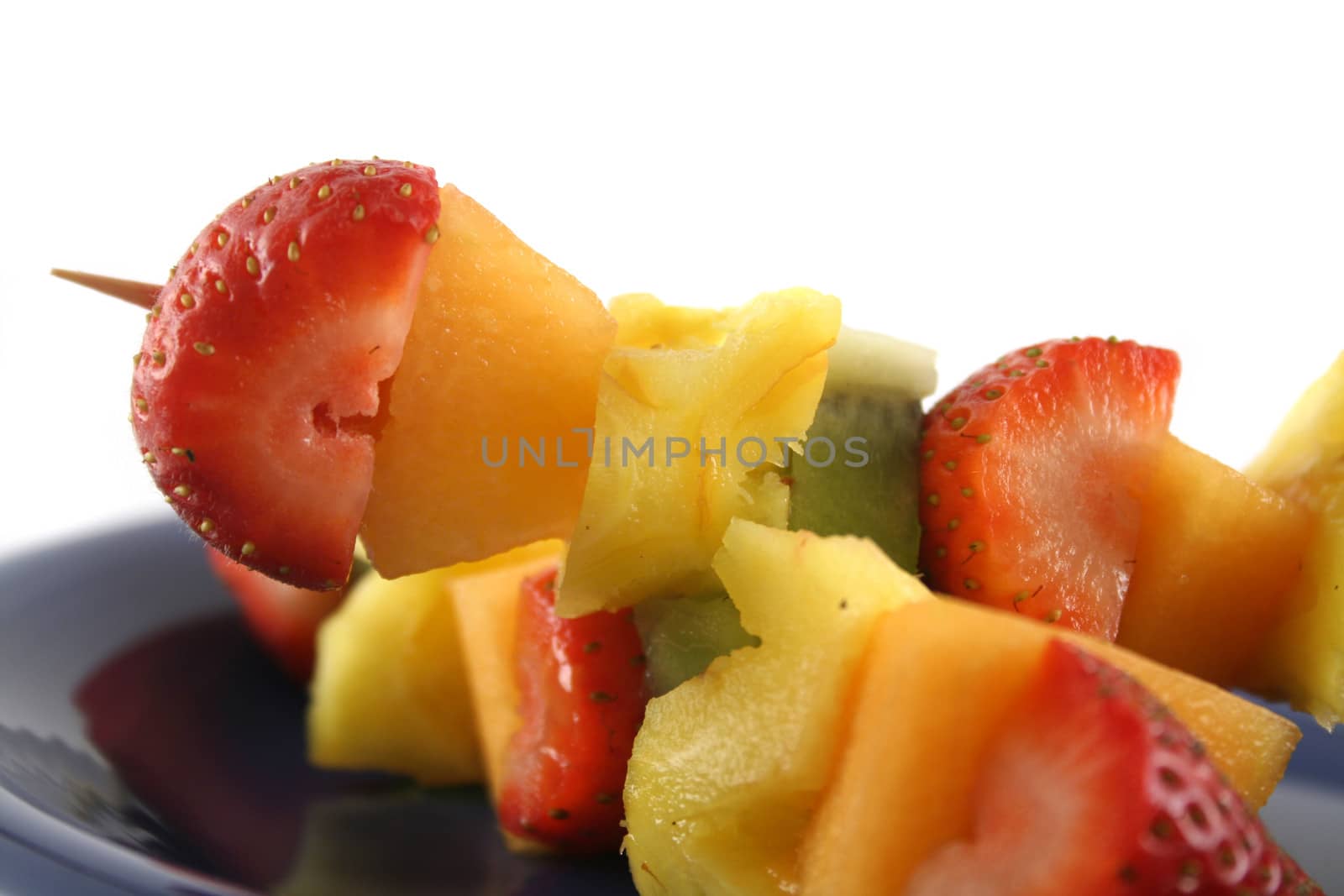 Colorful kebabs made with skewers of fresh fruit pieces.