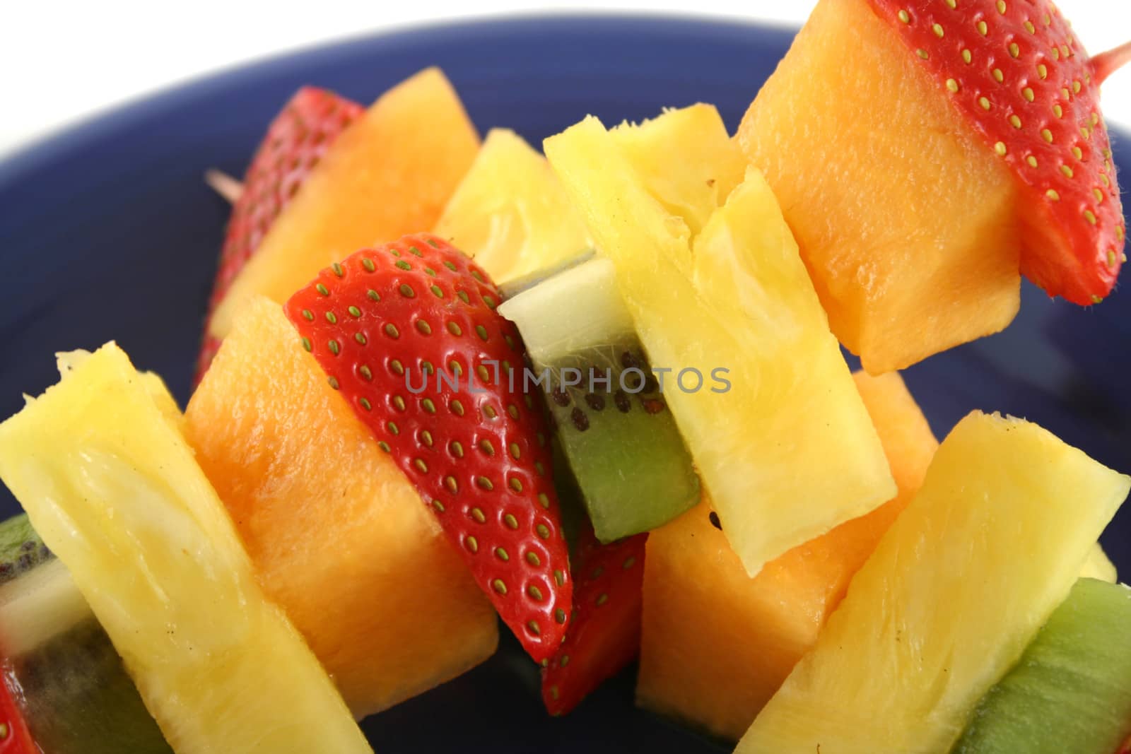 Colorful kebabs made with skewers of fresh fruit pieces.