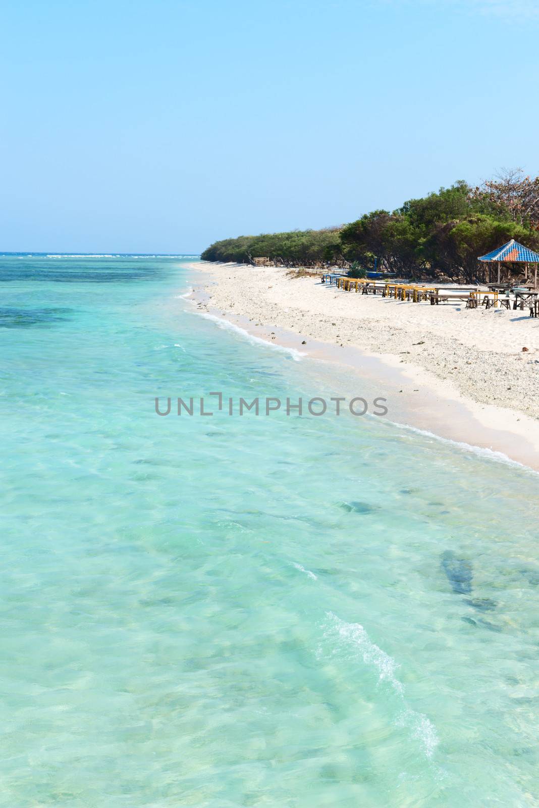 Beautiful beach with blue clean water and seaside cafe on tropical beach. Selective focus on front water.