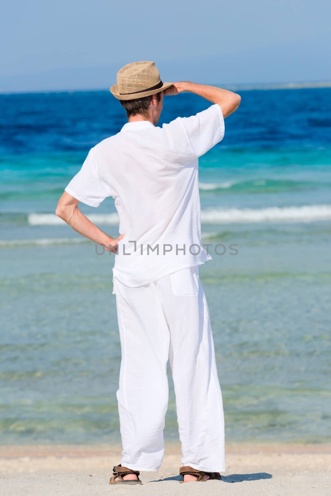 Man in a white suit against the sea by iryna_rasko