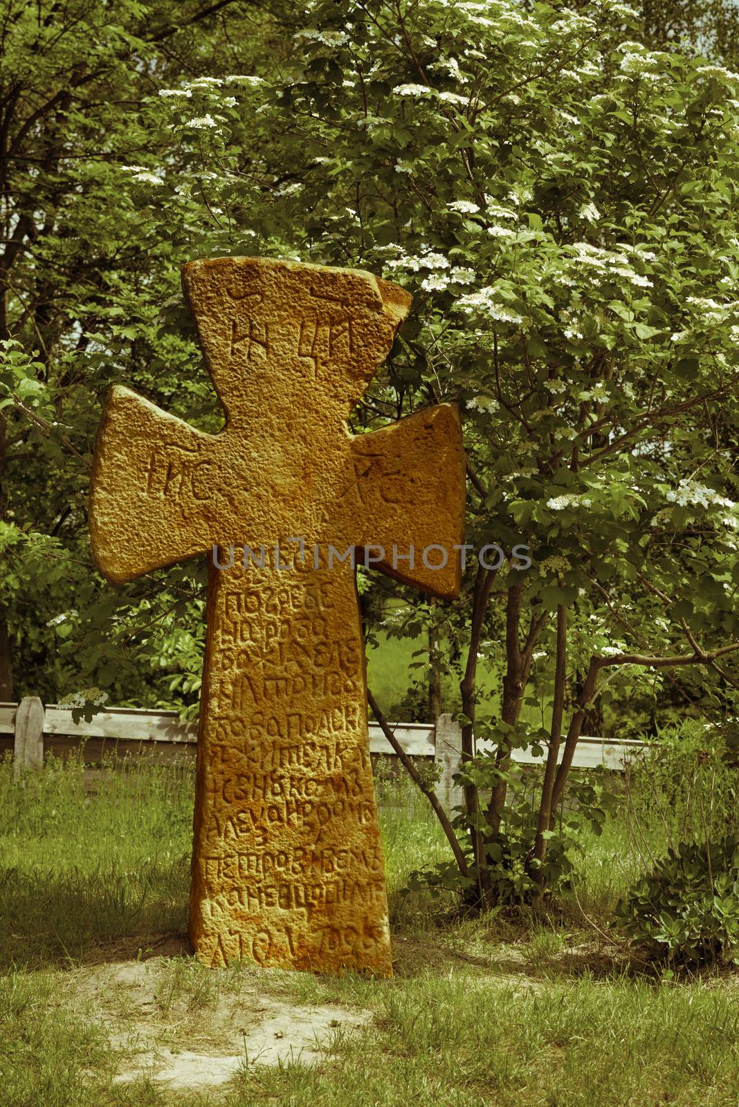 Slavic ancient stone cross in green forest, Eastern Europe