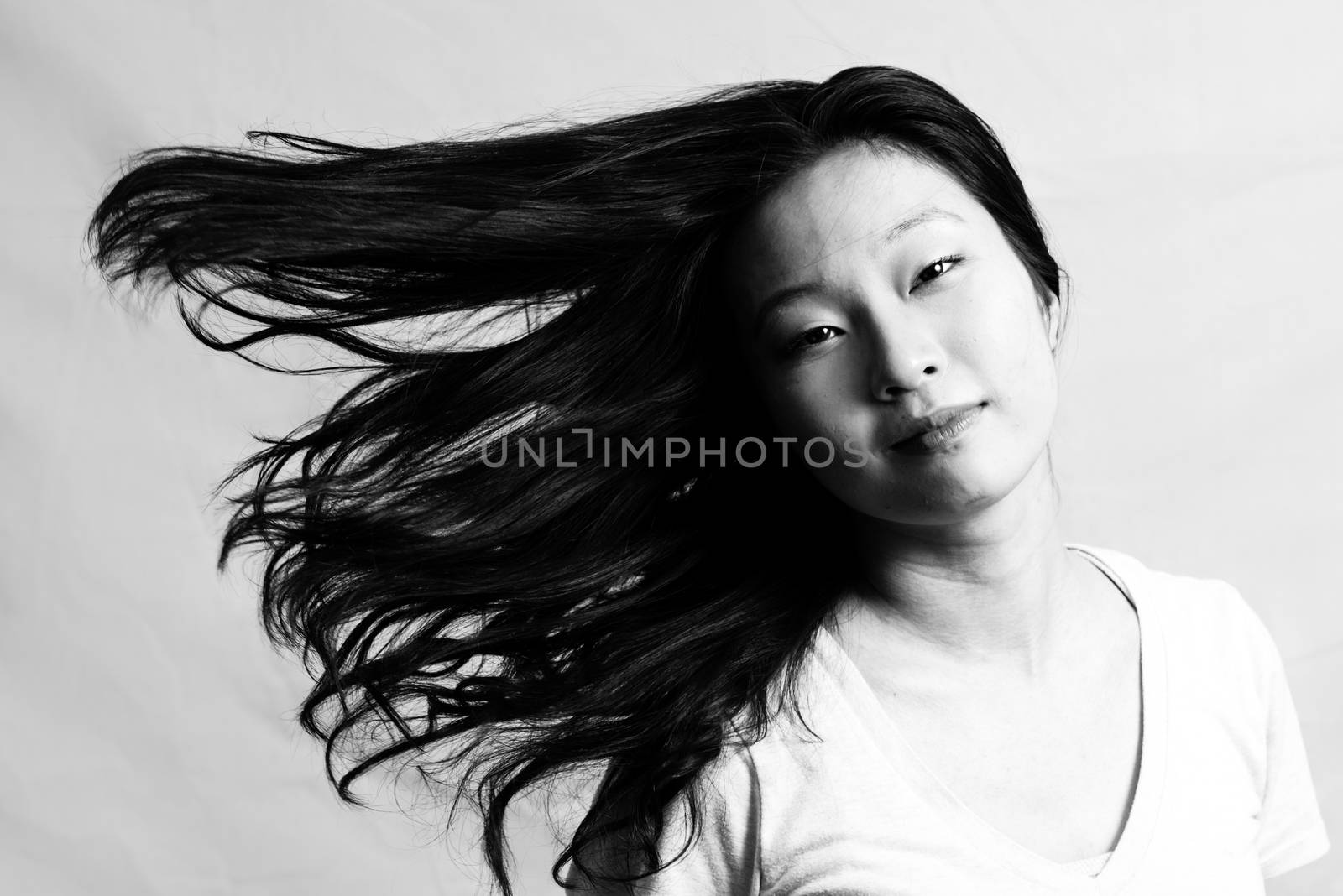 Portrait of beautiful young woman flicking her hair and posing, black and white style