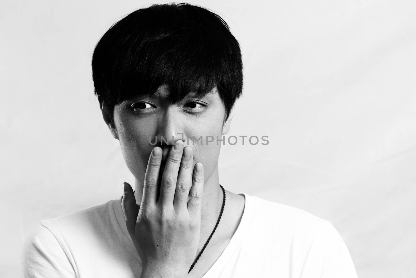 Portrait of handsome young man smiles and looking shy, black and white style