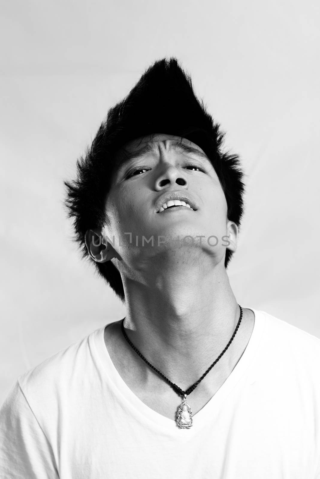 Portrait of handsome young man looking upset and flicking hair, black and white style