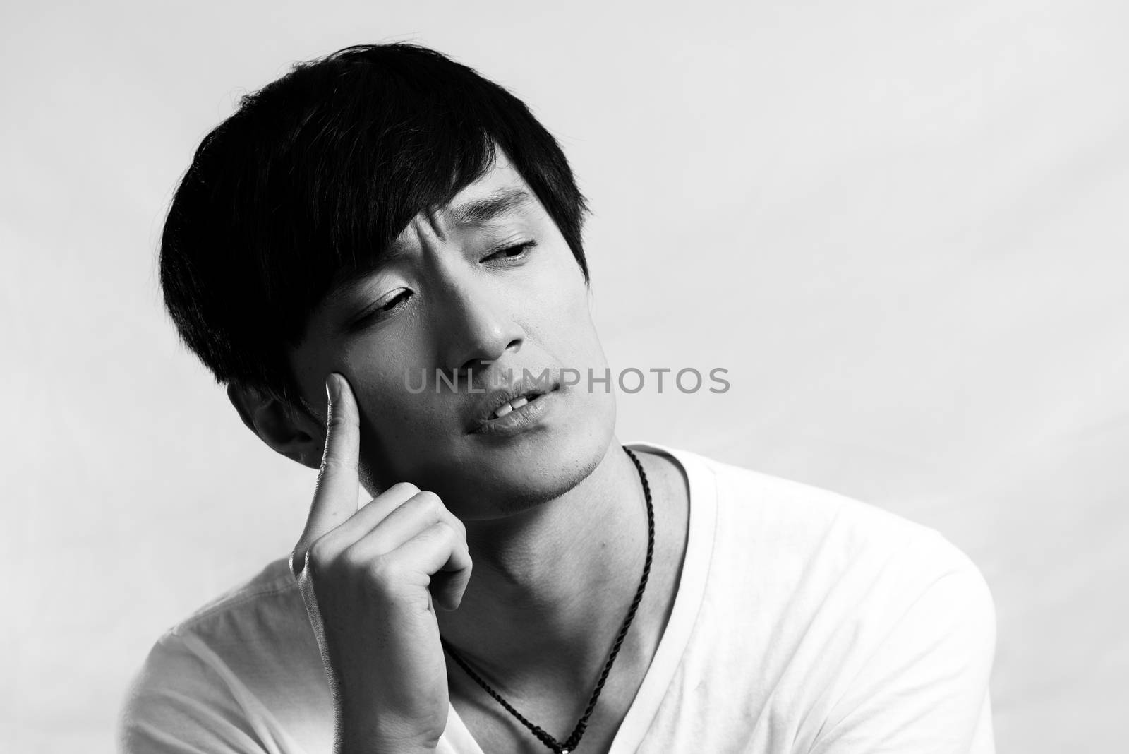 Portrait of handsome young man looking deep in thought, black and white style