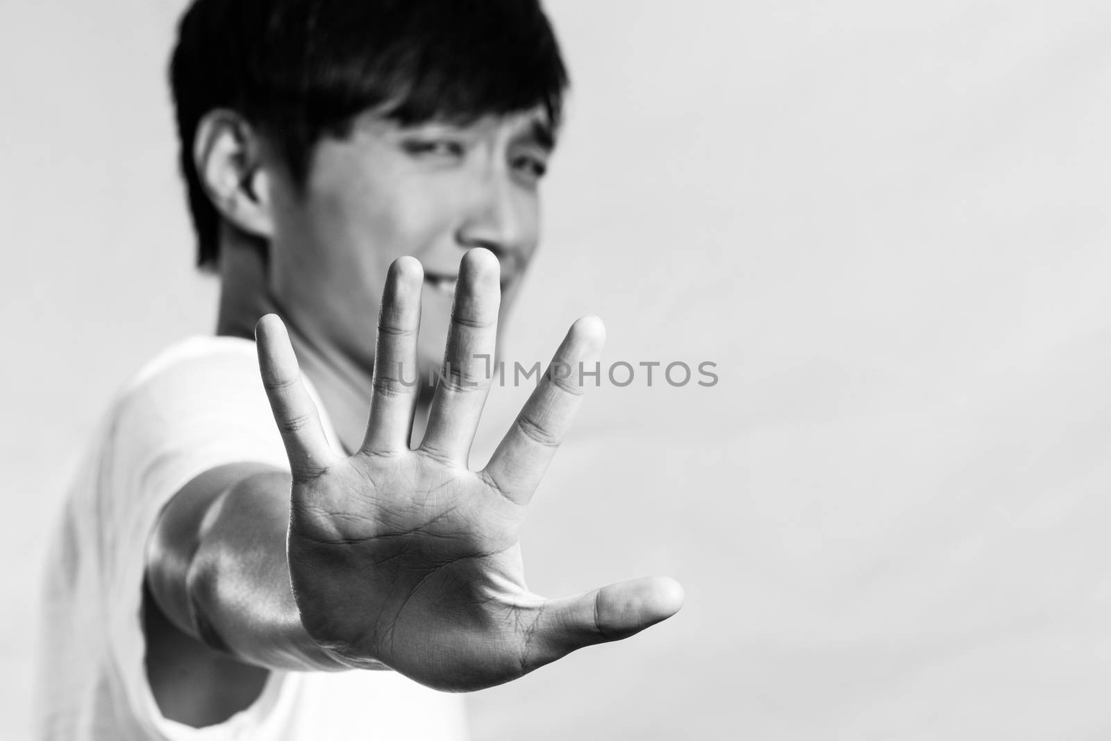 Young man holding up his hand by IVYPHOTOS
