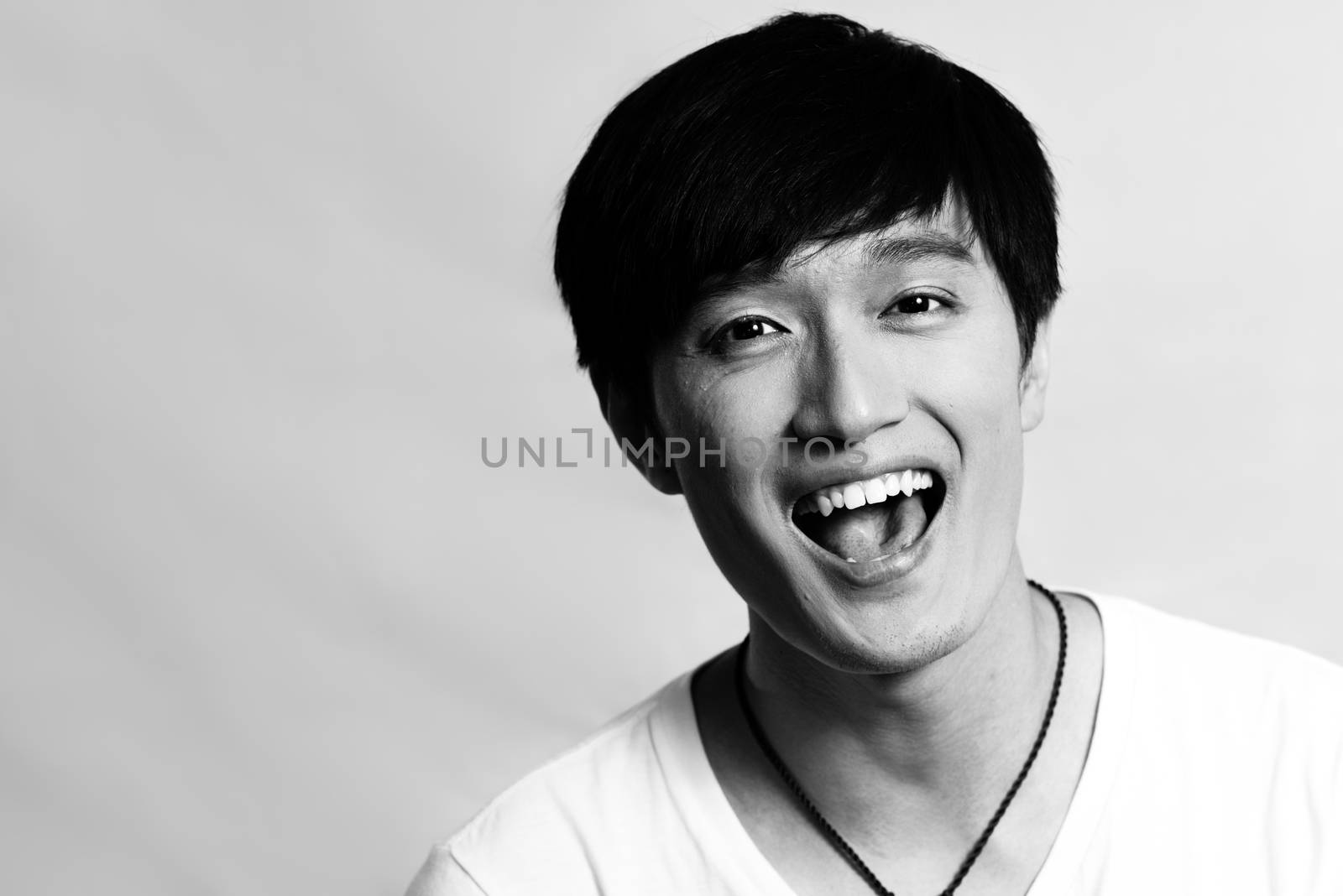 Portrait of young man laughing out loud, black and white style