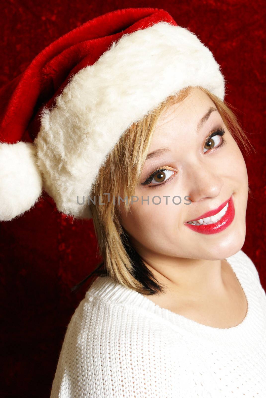 A happy young woman wearing a santa hat for the spirit of Christmas.