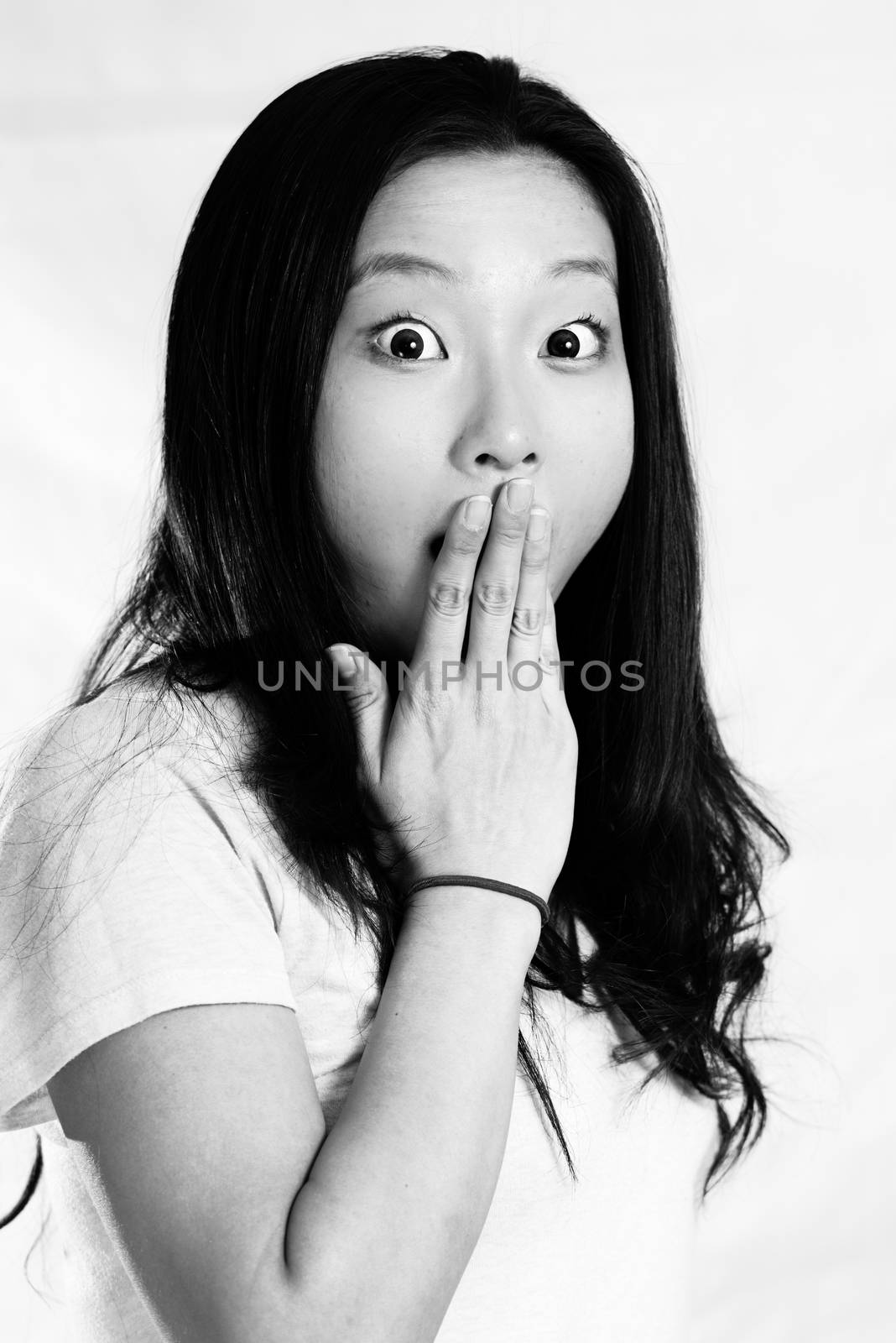 Young woman covering her mouth by IVYPHOTOS