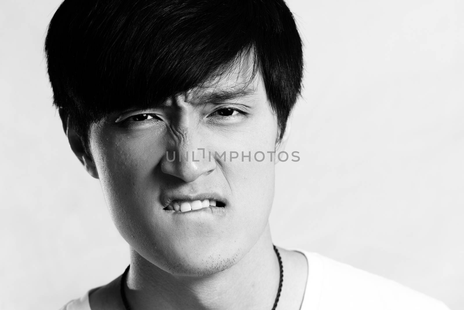 Portrait of young man looking angry and yelling, black and white style