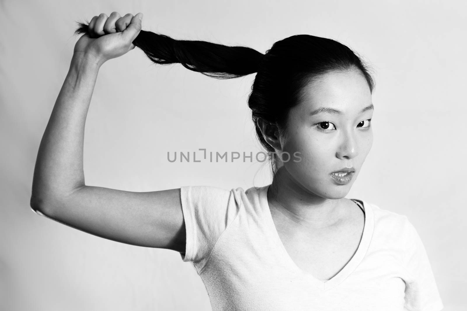 Portrait of lonely young woman pulling her hair looking frustrated, black and white style